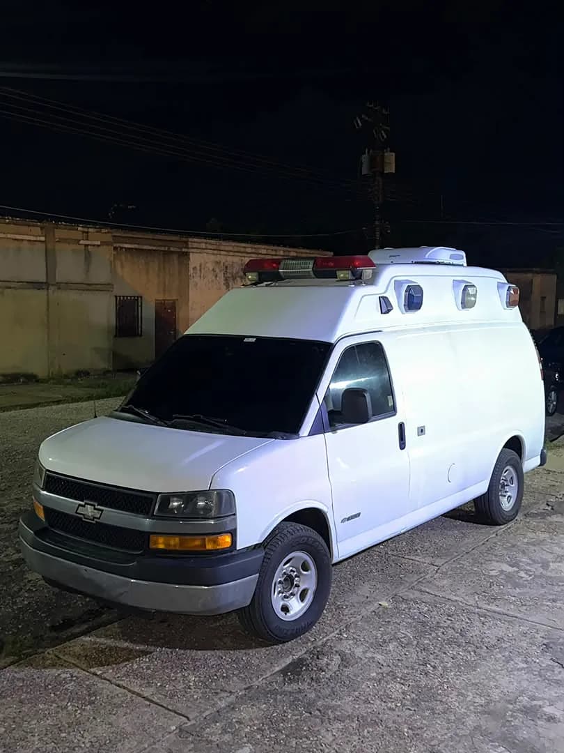 Ambulancia Chevrolet Express blanca con el equipo en el techo