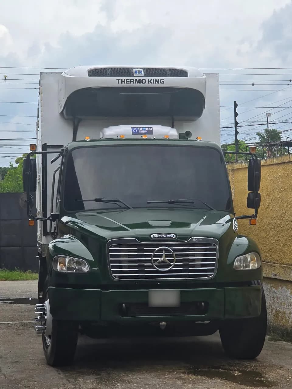 Camión Freightliner M2 verde con la unidad del aire acondicionado sobre el techo de la cabina
